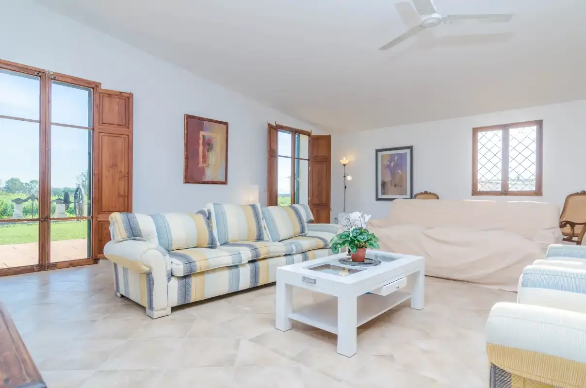 A bright living room with striped seating and a white coffee table.