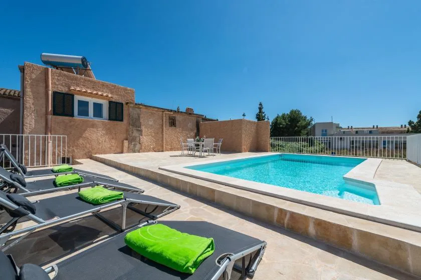 A rooftop pool area with turquoise water and loungers on the surrounding deck.