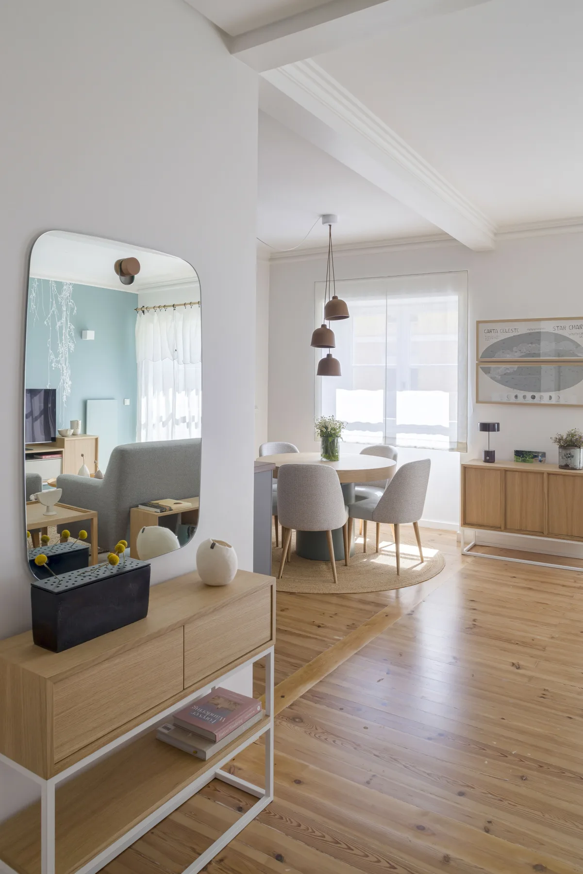 Una luminosa zona de comedor y estar con mesa, asientos y una ventana grande.