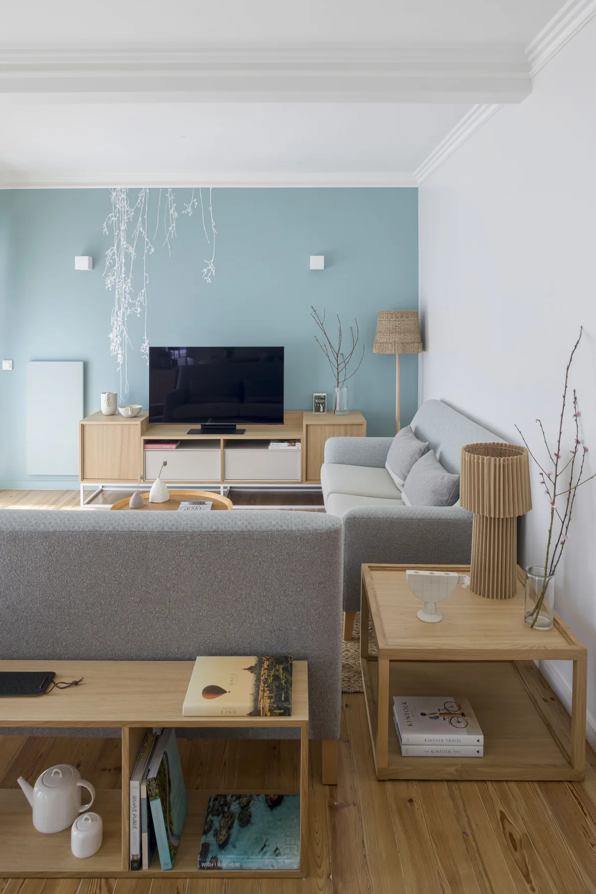 Sala de estar con asientos, un televisor y mesas de madera.