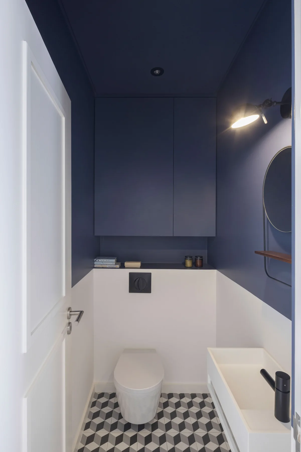 Un baño compacto con inodoro, bañera y suelo estampado.