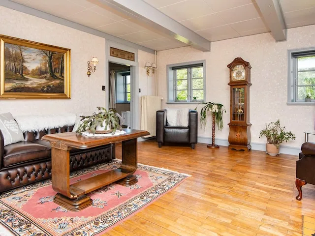 A living room with a wooden coffee table and patterned rugs.