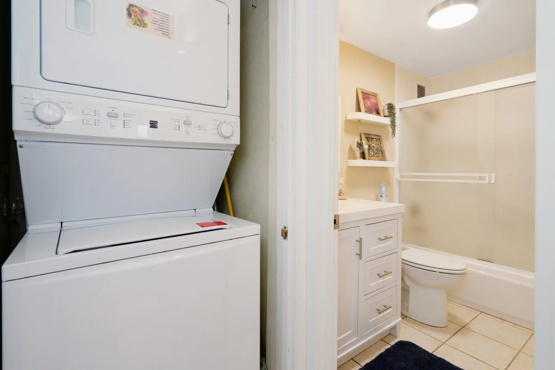 Zona de lavandería junto a un baño con lavabo y bañera.