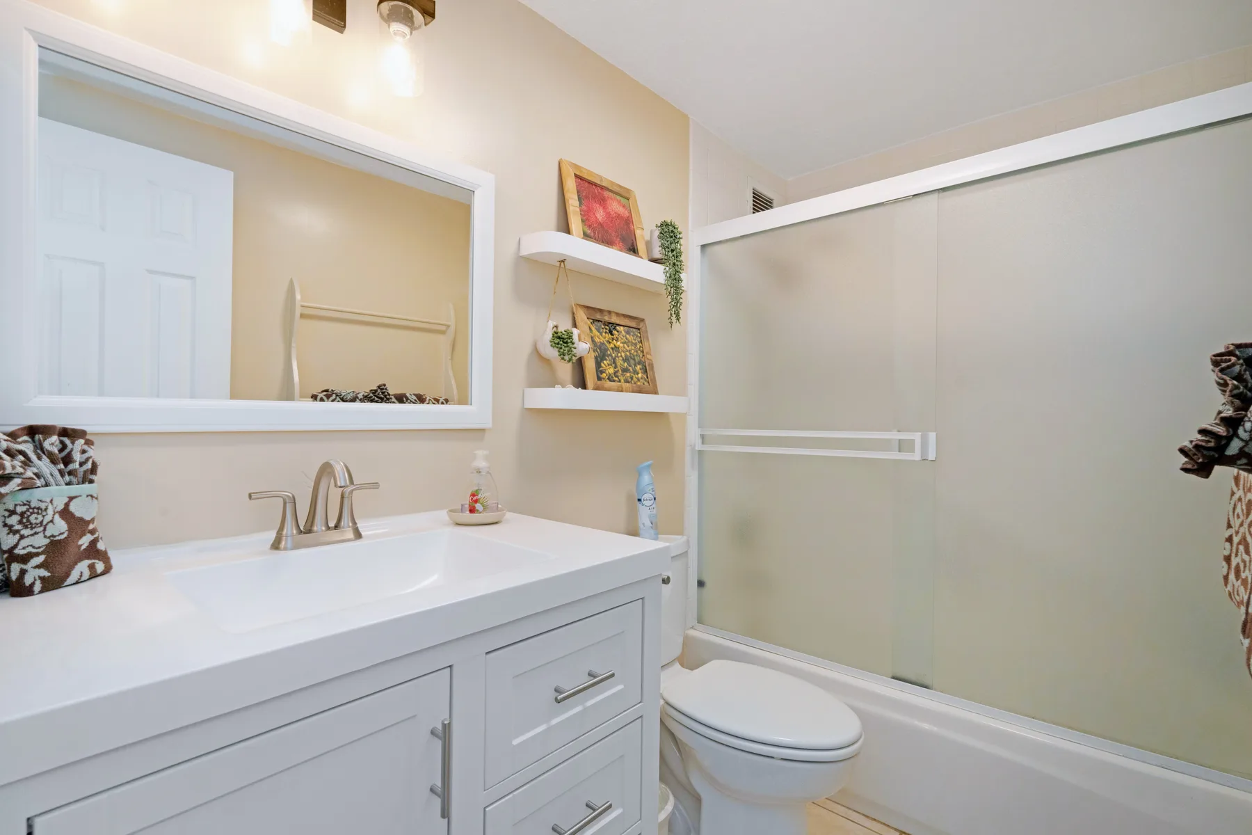 Un baño con lavabo, espejo, inodoro y bañera.