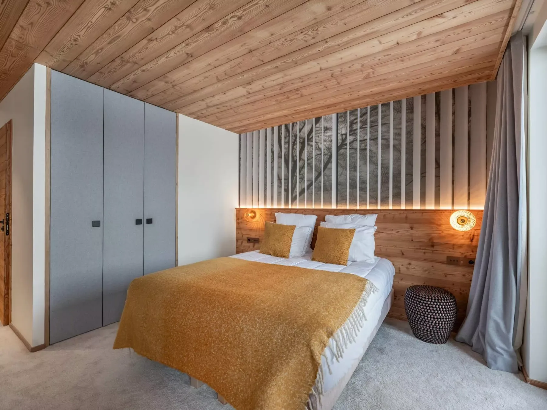 Un dormitorio con una cama doble, paneles de madera y cortinas largas.