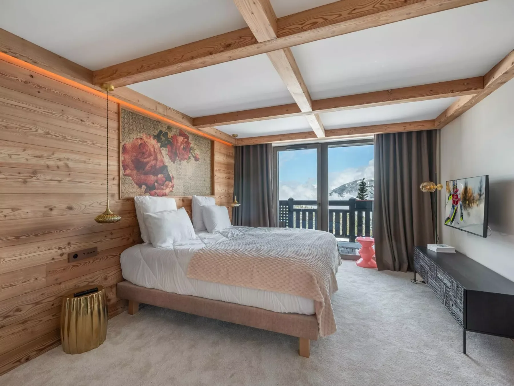 Un dormitorio con una cama junto a una gran ventana con vista a un balcón.