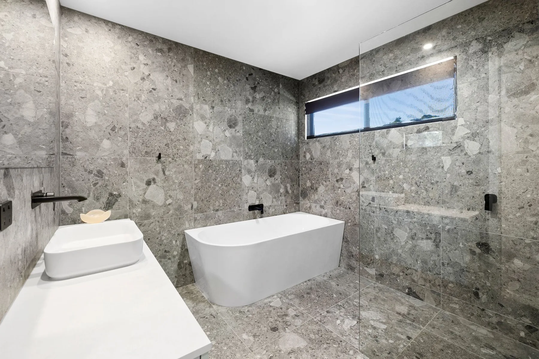 Un baño con bañera exenta, lavabo y ventana.