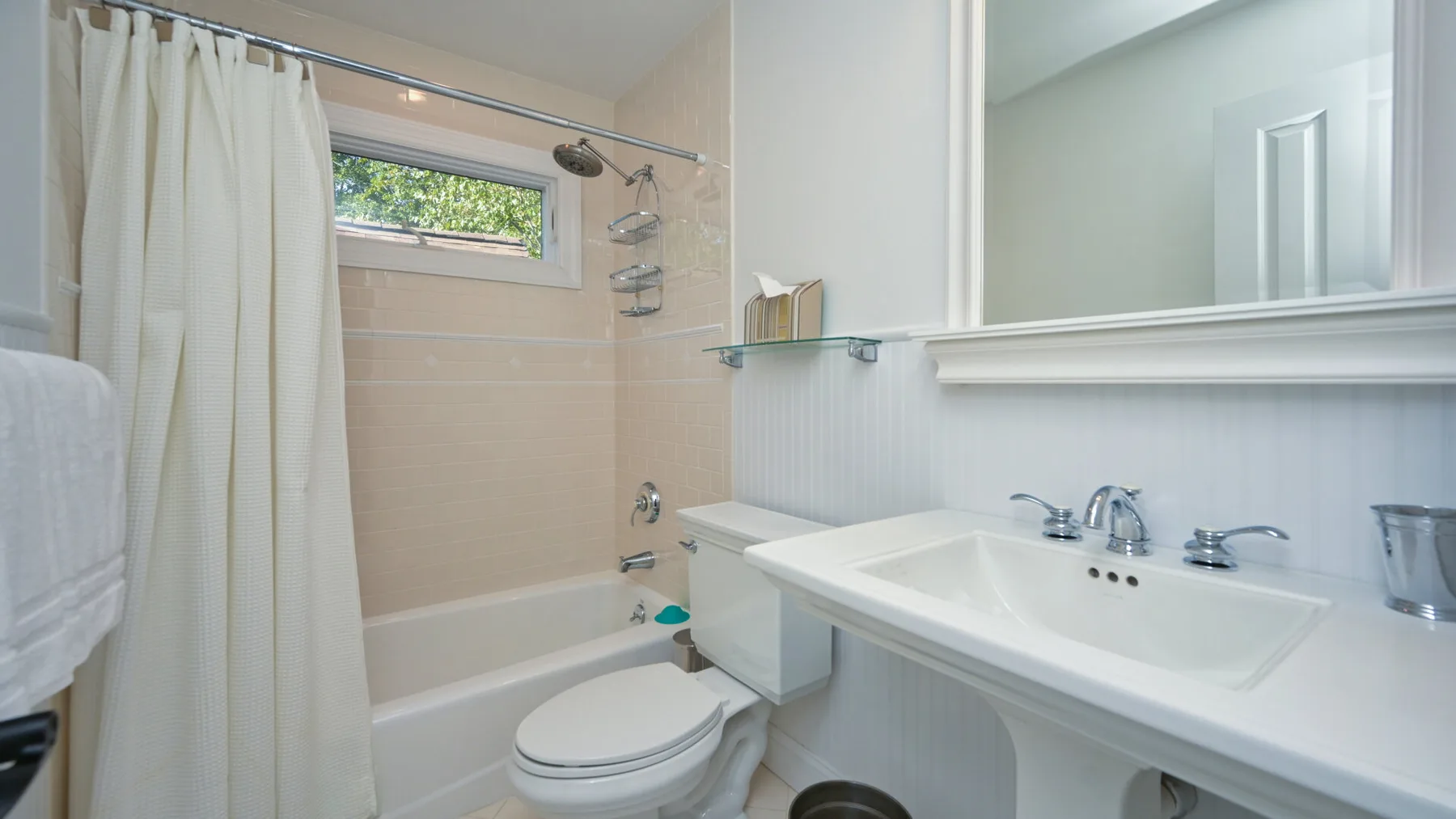 Un baño con bañera, cortina de ducha, inodoro y lavabo.