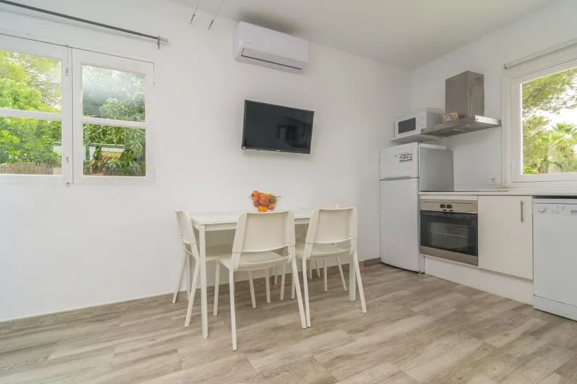 A bright kitchen and dining area with a table, chairs, and white cabinetry.