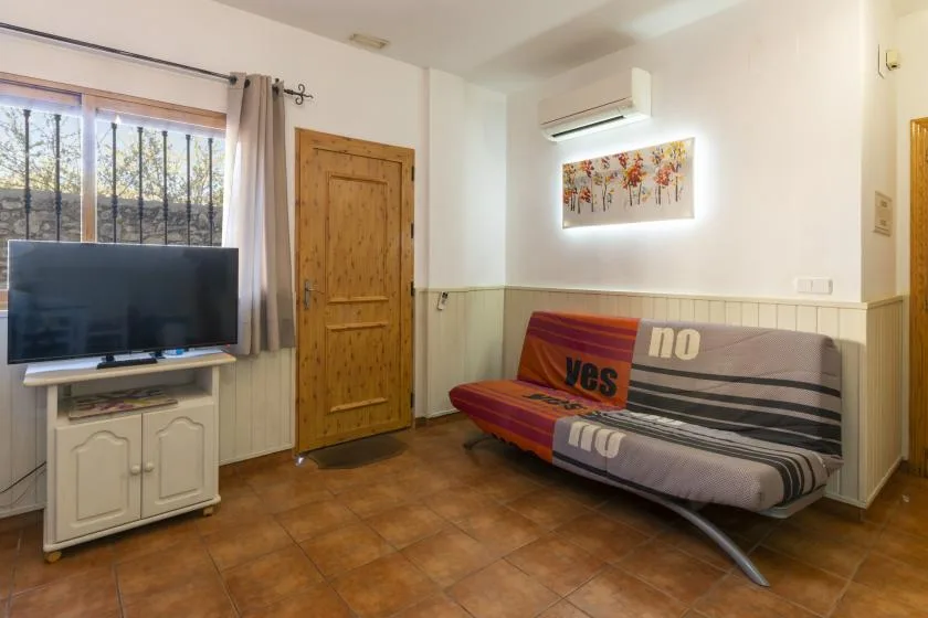 A living room with a television beside a striped sofa.