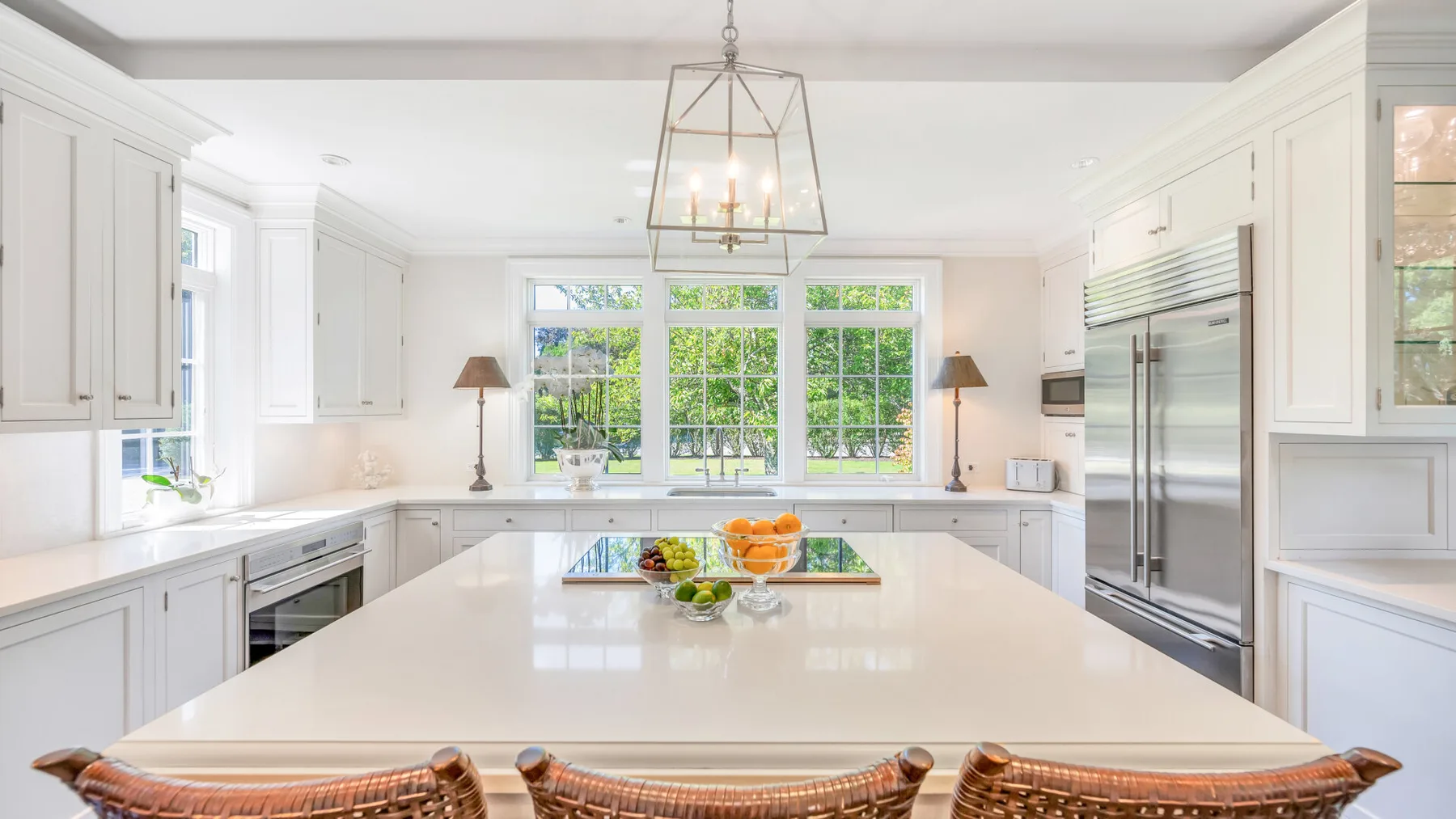 Una cocina luminosa con gabinetes blancos y una gran isla central.