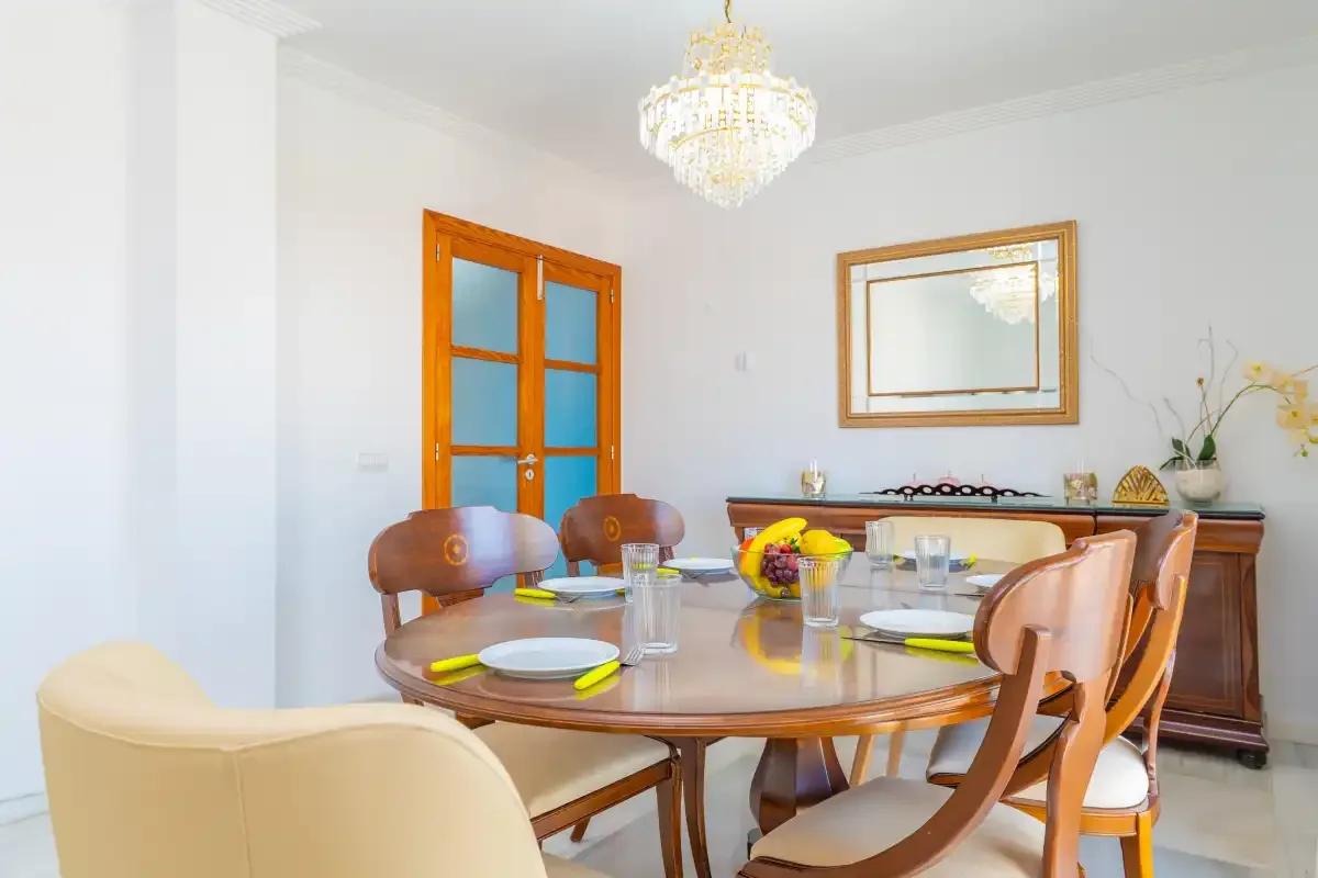 Un comedor con una mesa puesta y asientos de madera.