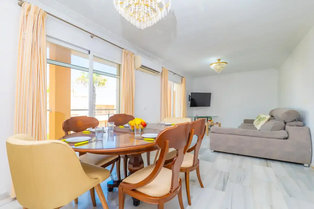 Una luminosa sala de estar y comedor con mesa, asientos y sofá.