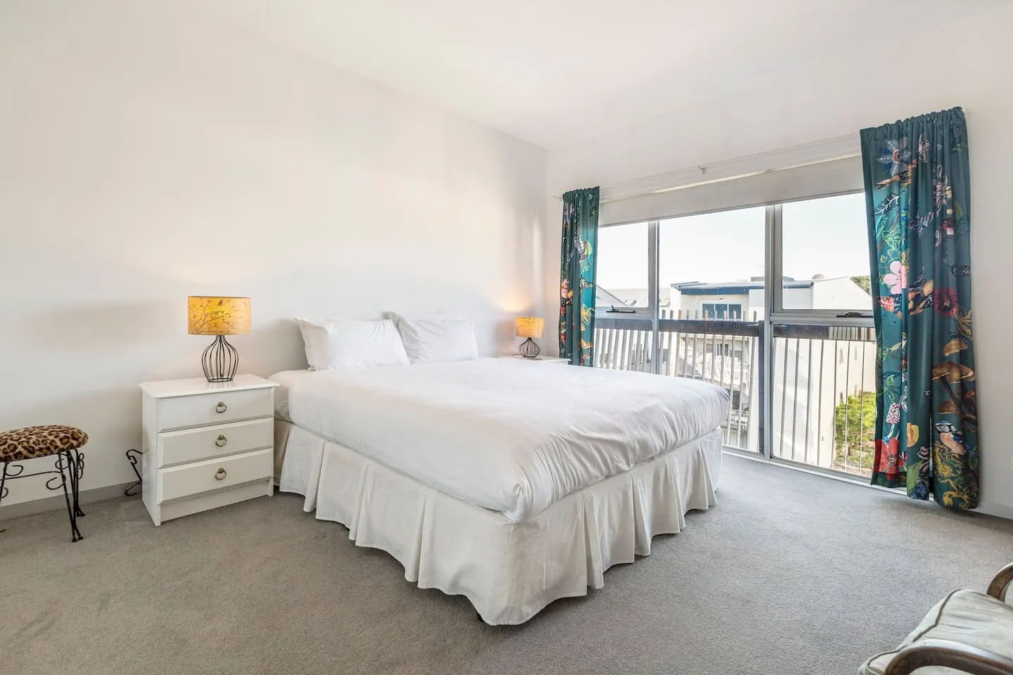 Un dormitorio con una cama grande y puertas de vidrio que dan a un balcón.