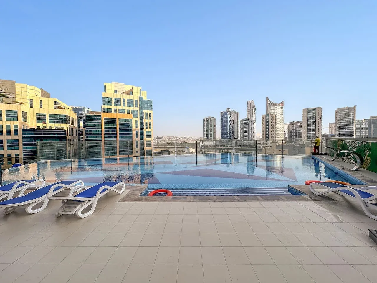 Una piscina en la azotea tiene vistas a edificios altos cercanos.