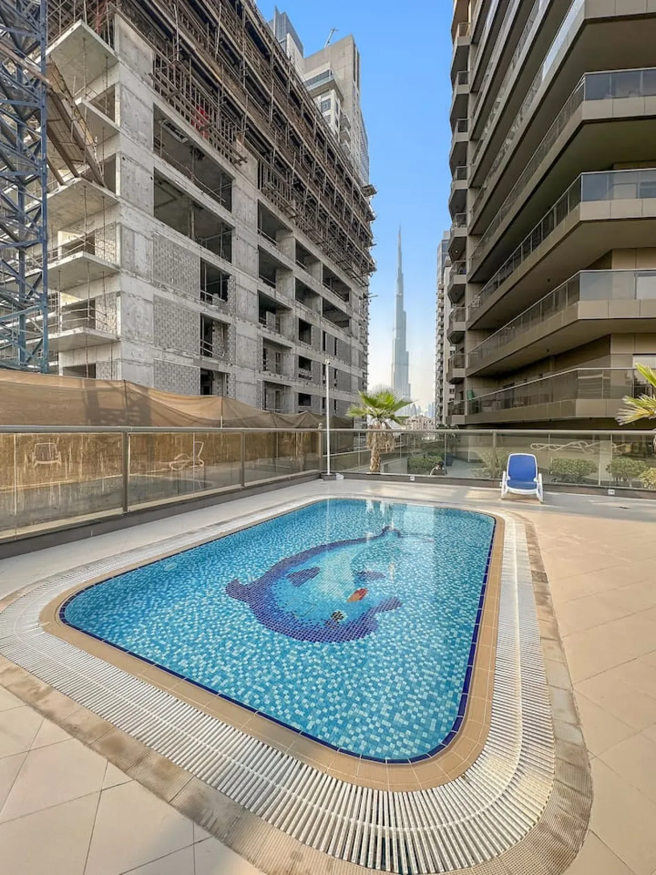 Una piscina al aire libre está entre dos edificios de apartamentos.