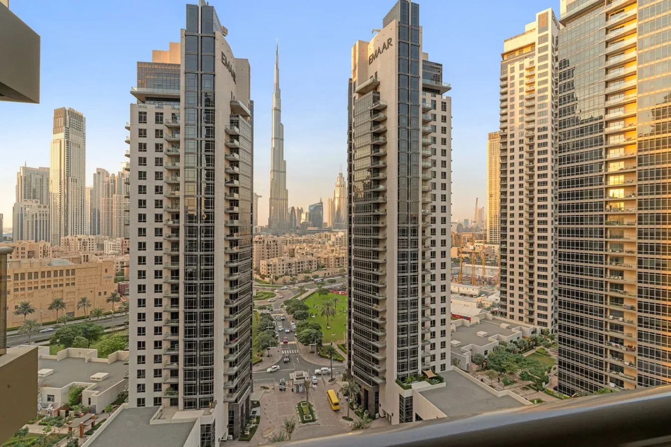 Un horizonte urbano entre edificios altos, con calles y zonas ajardinadas abajo.