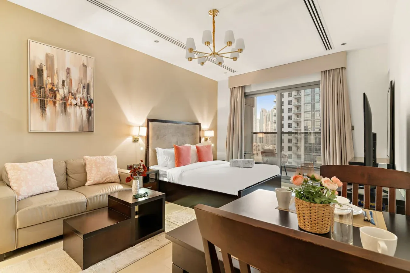 Un dormitorio tipo estudio moderno con cama, zona de estar y una gran ventana con vistas urbanas.