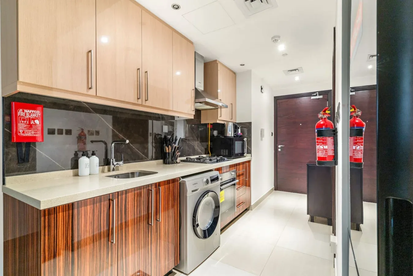 Una cocina moderna con gabinetes de madera clara, una encimera y electrodomésticos.