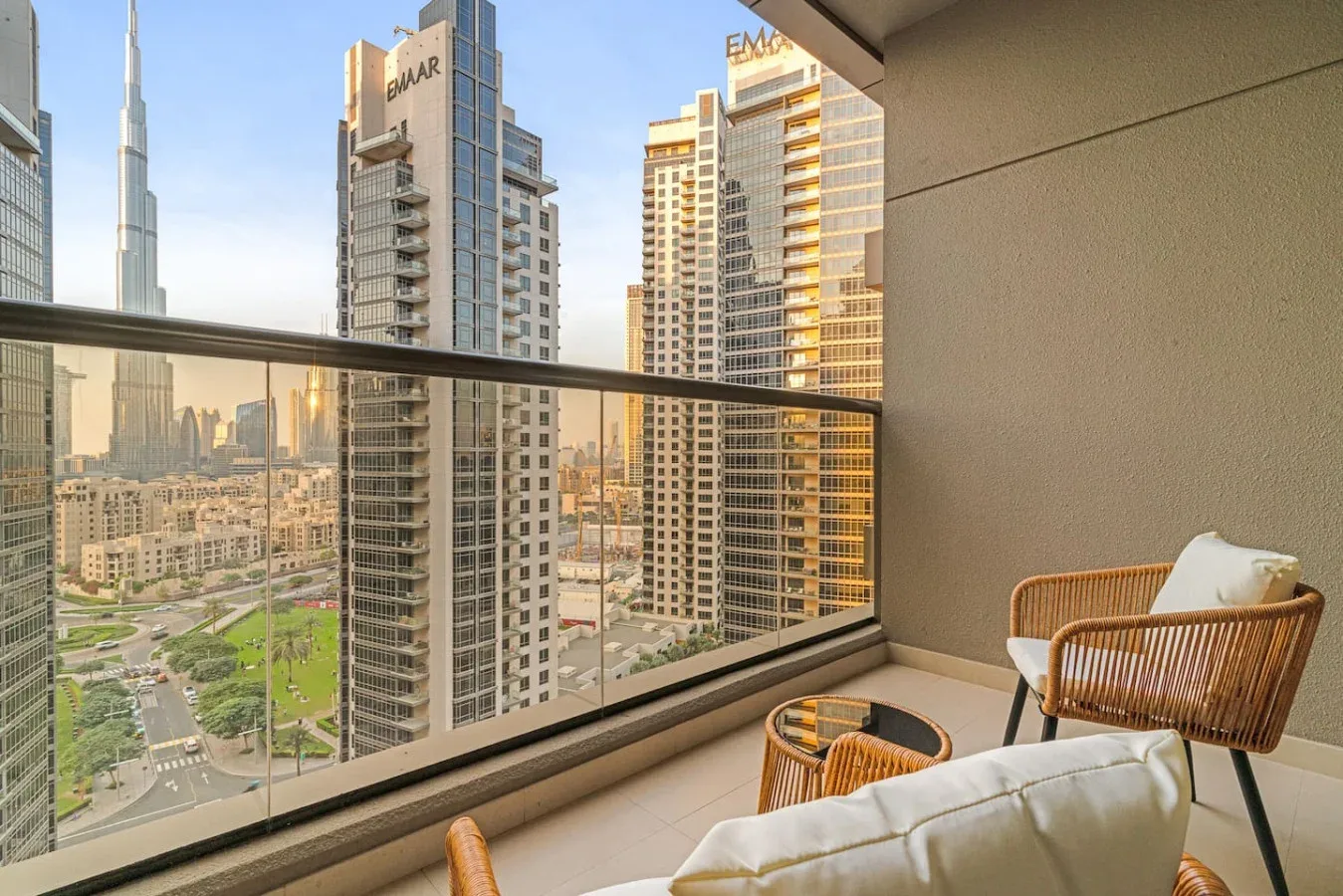 Una zona de estar en un balcón da a edificios altos cercanos y al Burj Khalifa.