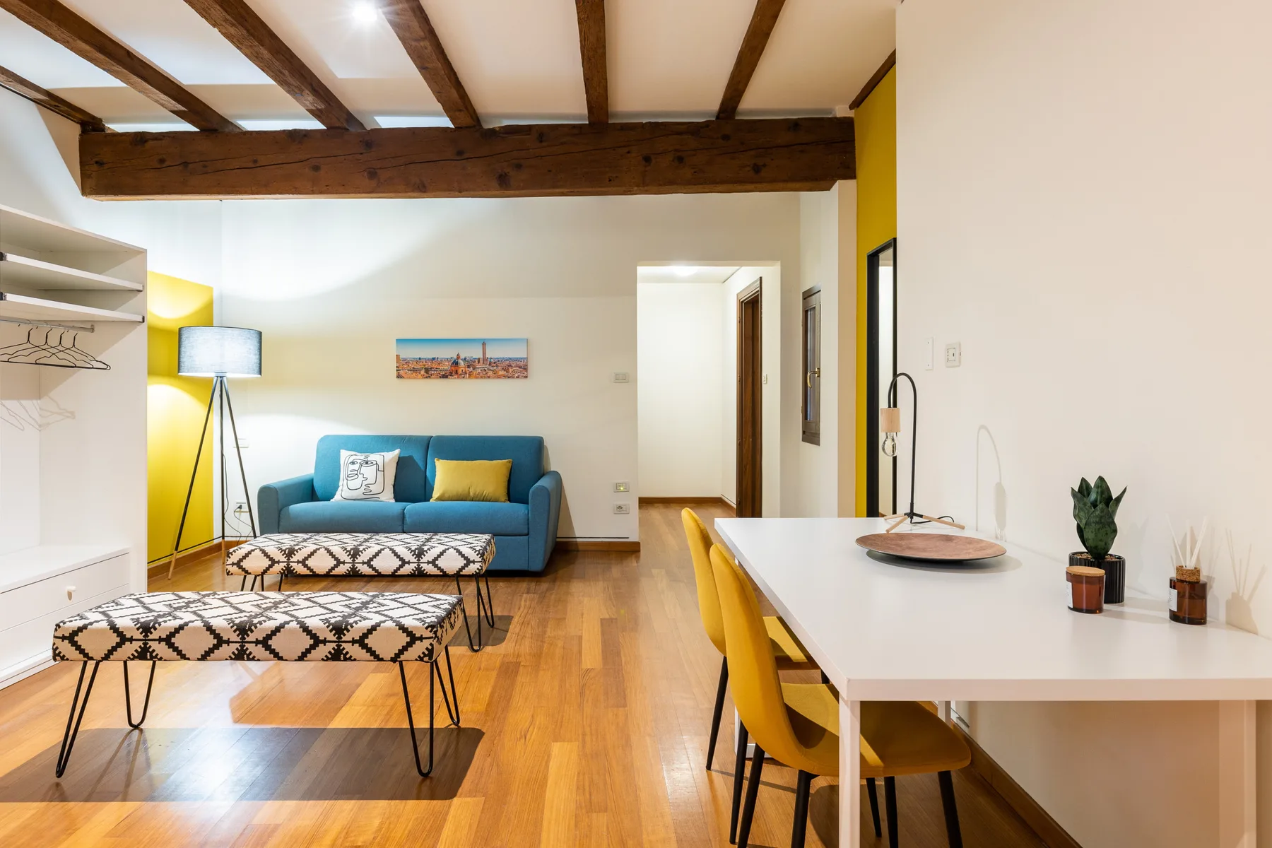 Una luminosa sala de estar y comedor cuenta con un sofá azul y una mesa larga.