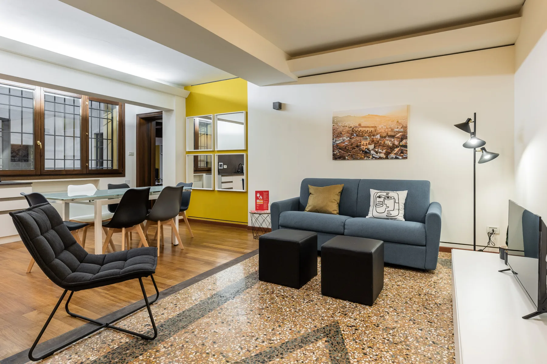 Sala de estar con asientos, una mesa de centro y un comedor contiguo.