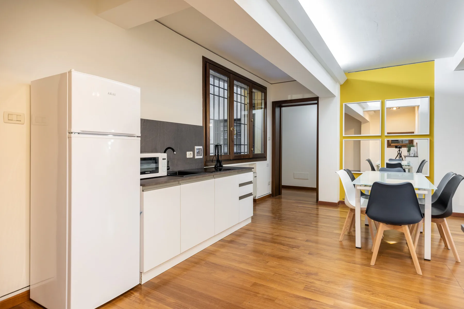 Una cocina y comedor con armarios blancos y una mesa.