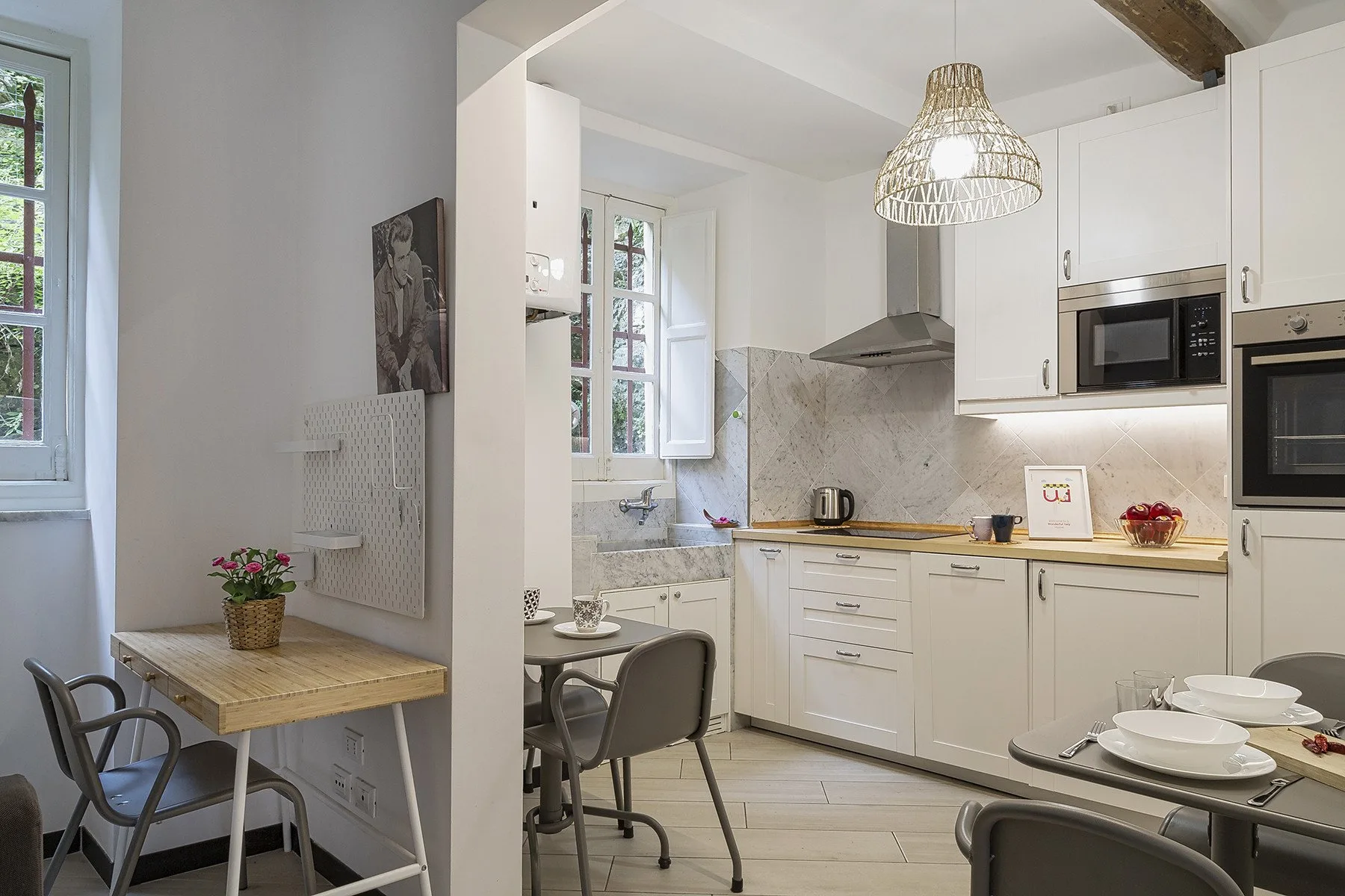 A bright kitchen with white cabinetry and a small dining table by the window.