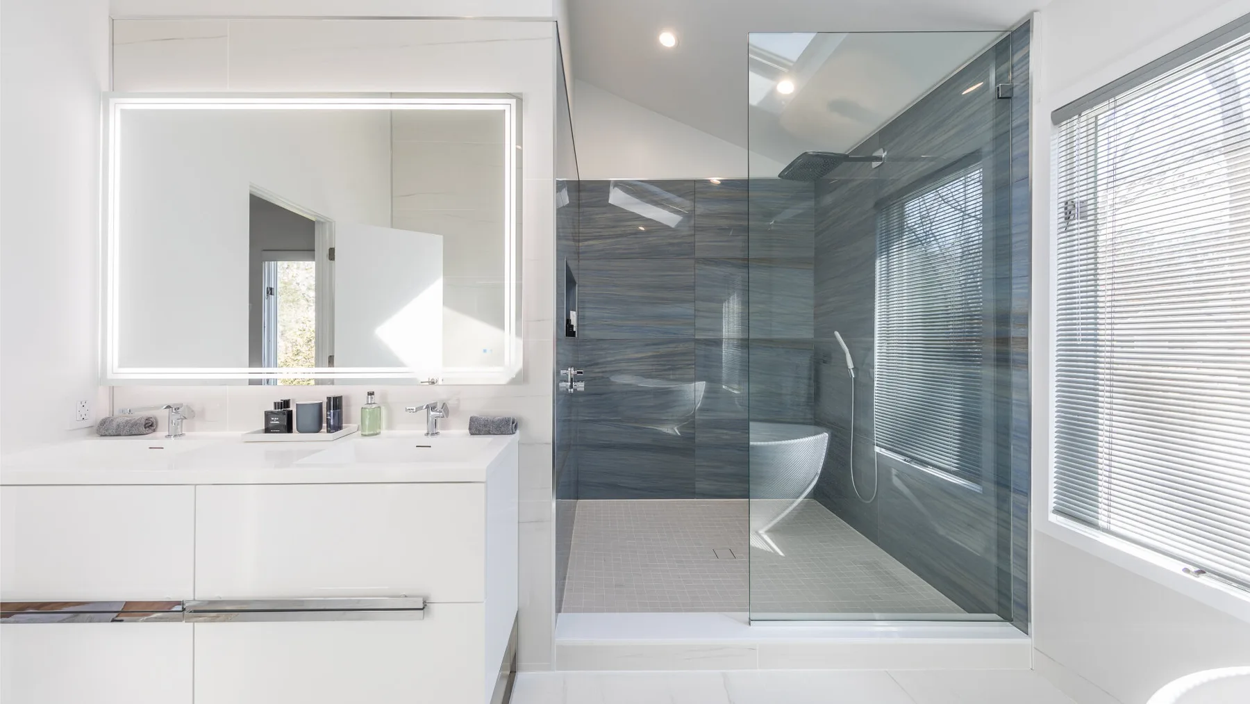 Un baño luminoso con un lavabo amplio y una ducha con mampara de vidrio.