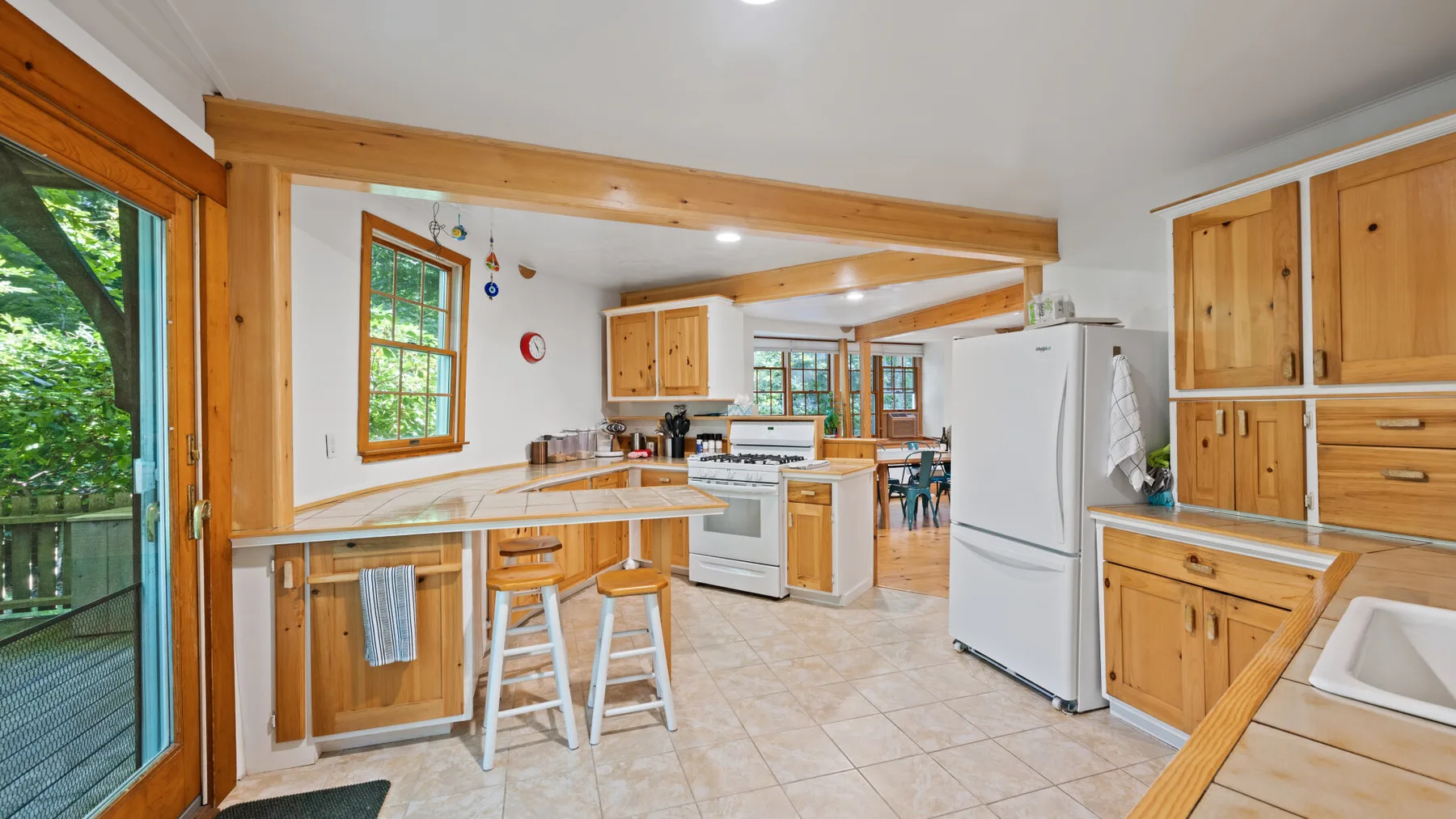 Una cocina luminosa con gabinetes de madera, una isla central y un comedor.