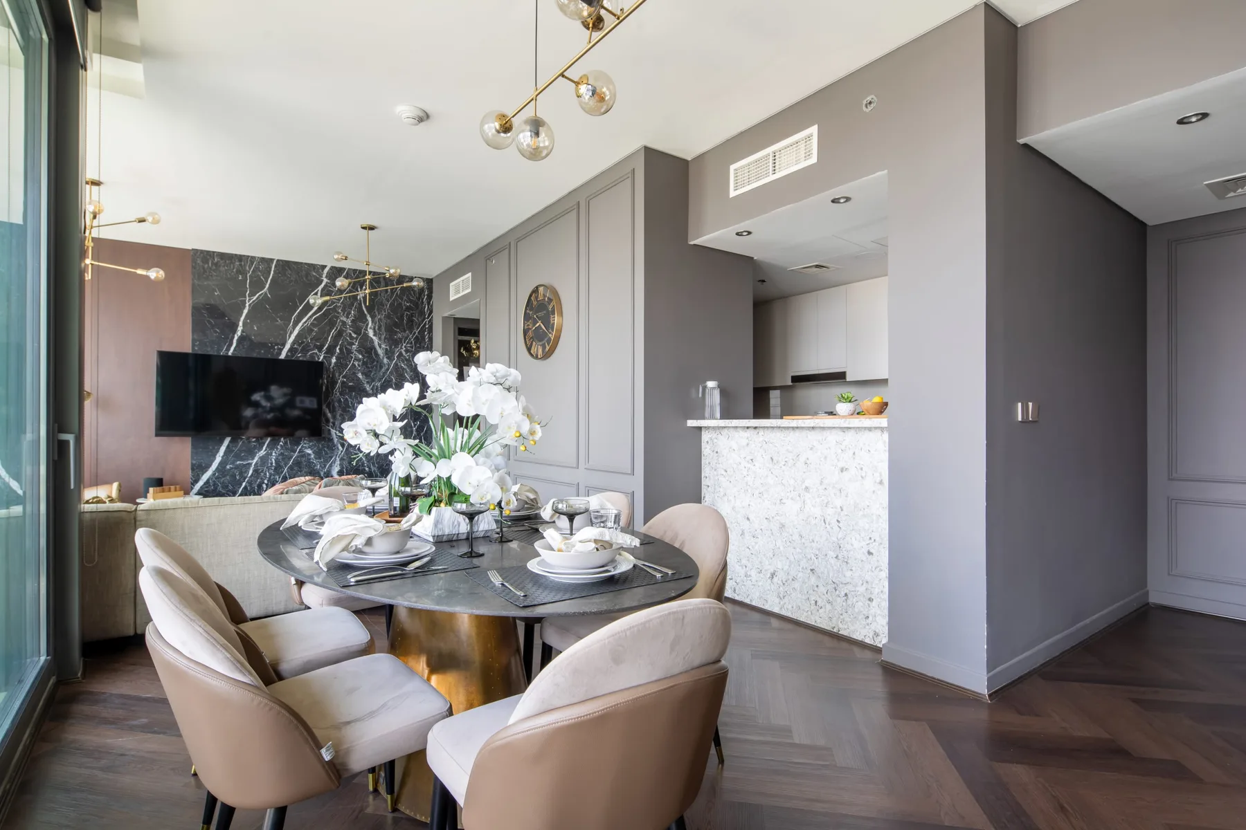 Comedor con una mesa redonda y asientos junto a una barra de cocina.