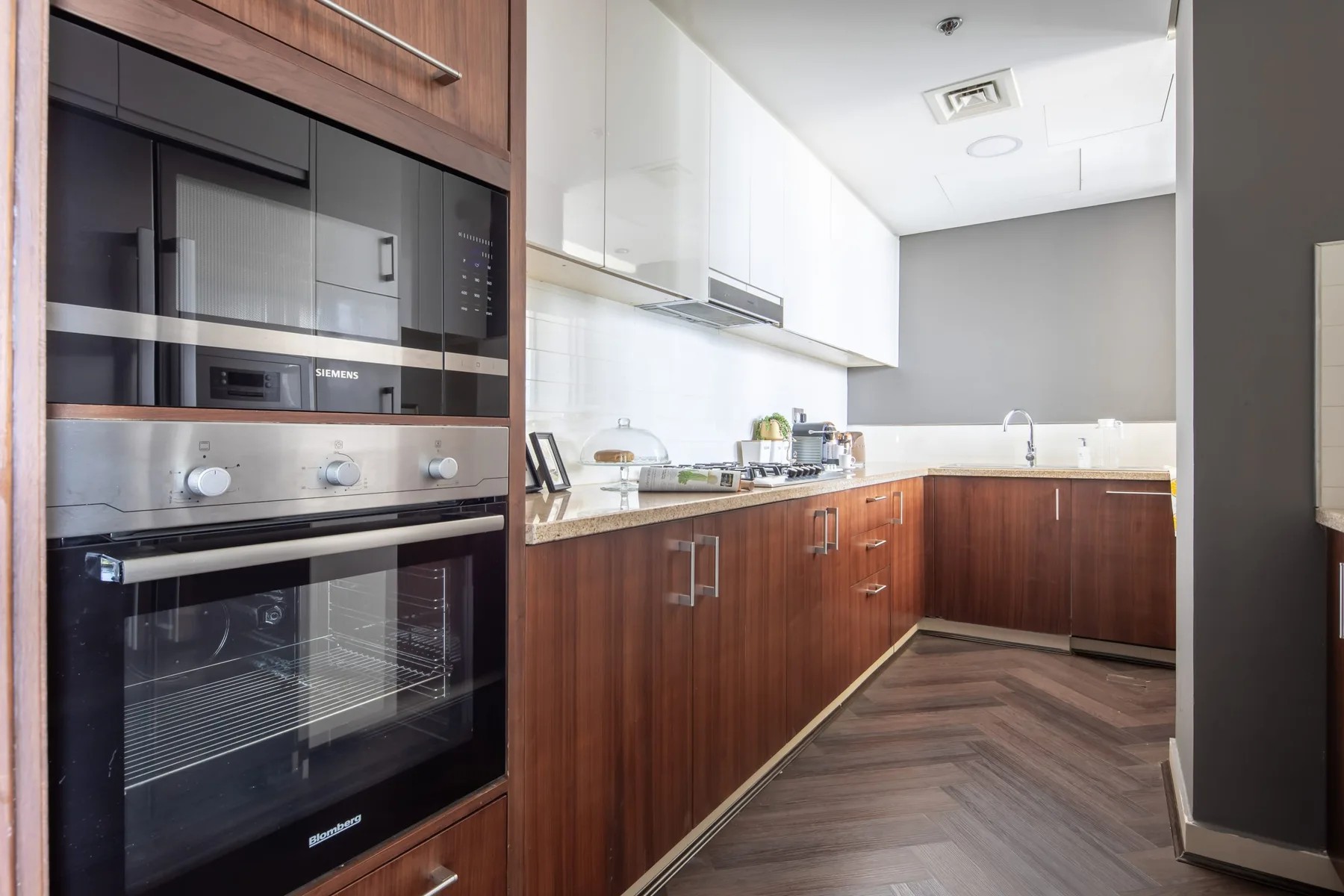 A modern kitchen with built-in appliances and wood cabinetry.