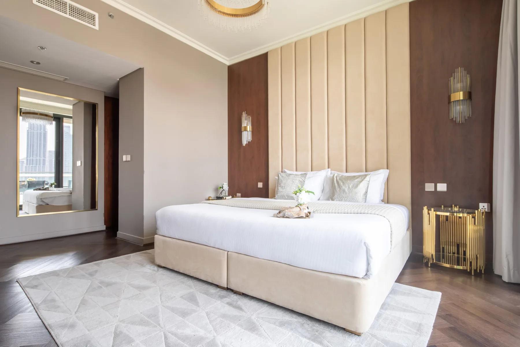 A bedroom with a neatly made bed and a light rug.