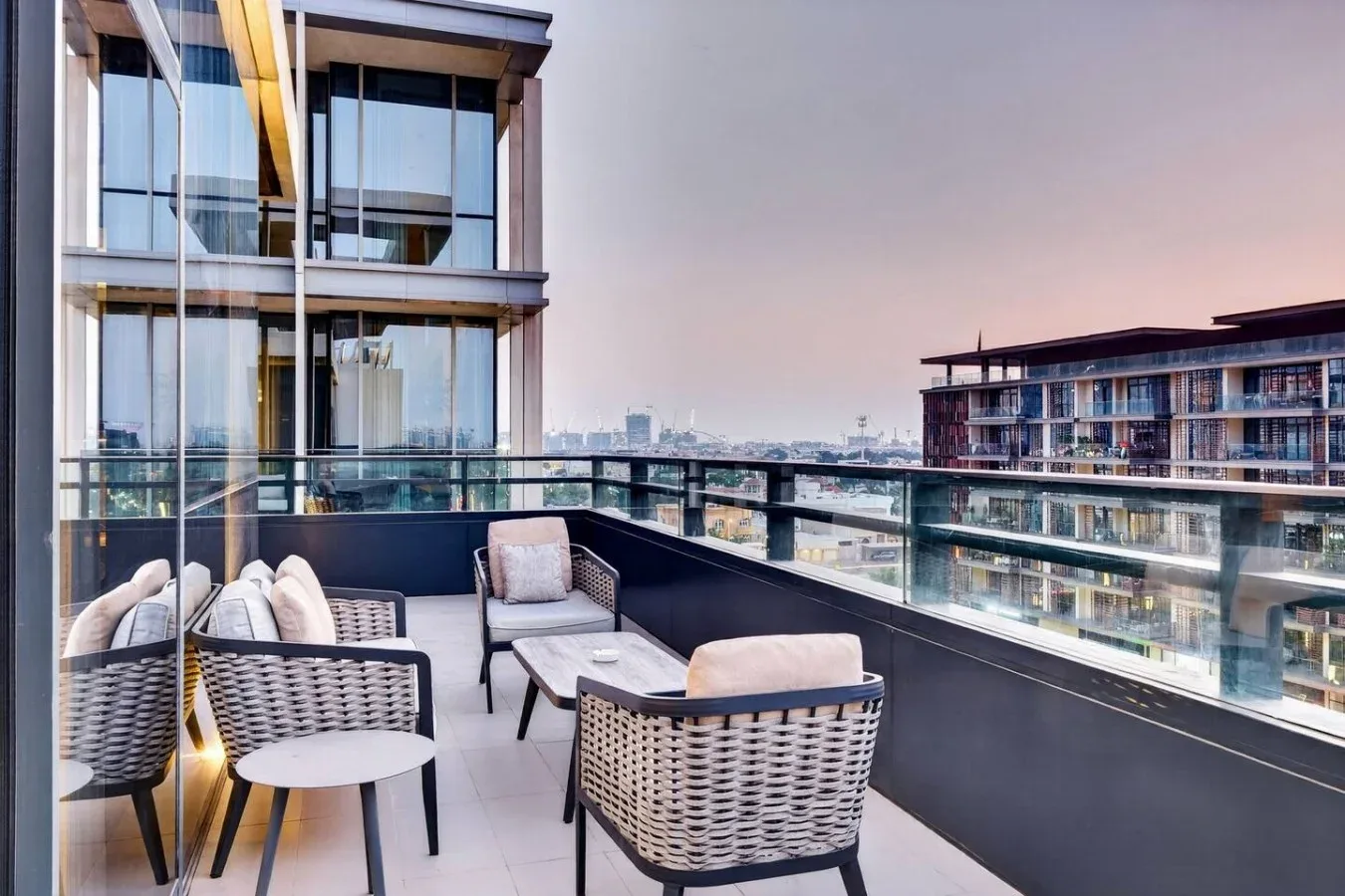 Una zona de estar en el balcón ofrece vistas a edificios cercanos y al horizonte de la ciudad.