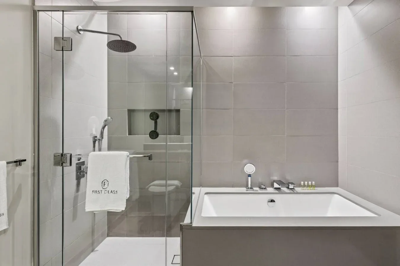 Un baño alicatado con una ducha de vidrio y una bañera.