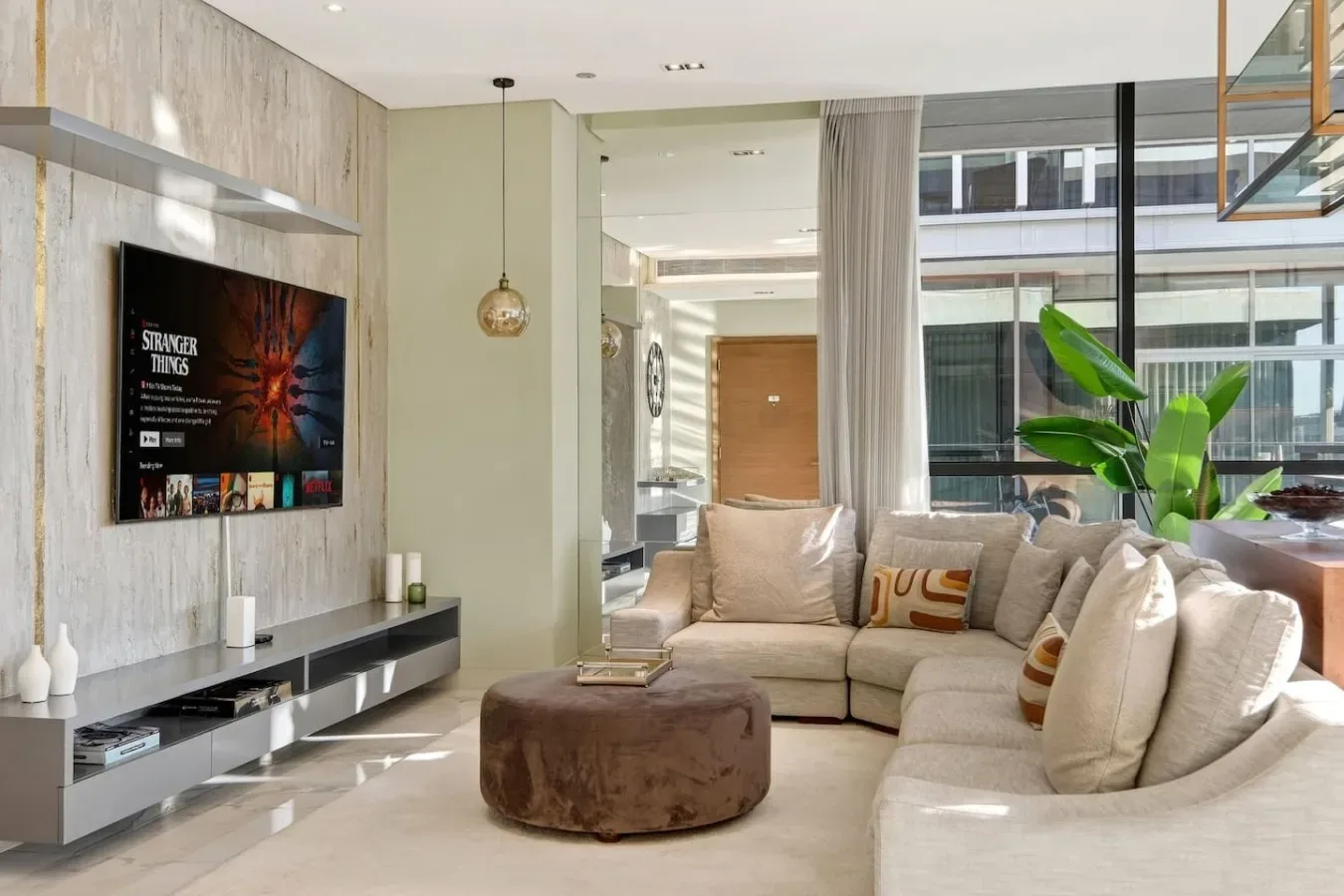 Una sala luminosa con una zona de asientos junto a grandes ventanas.