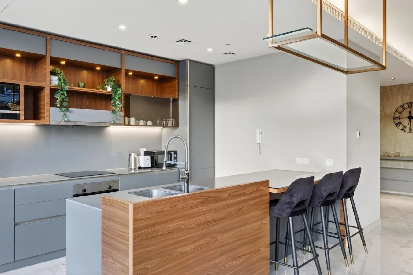 Una cocina moderna con una isla de frente de madera y asientos de barra.