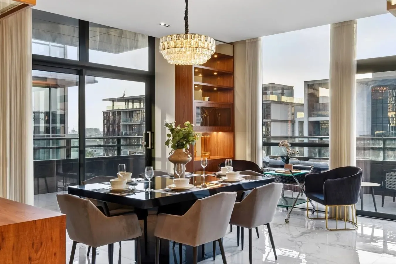Un comedor con la mesa puesta junto a ventanales.