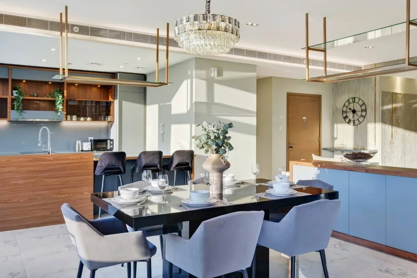 Comedor con la mesa puesta y una cocina abierta al fondo.