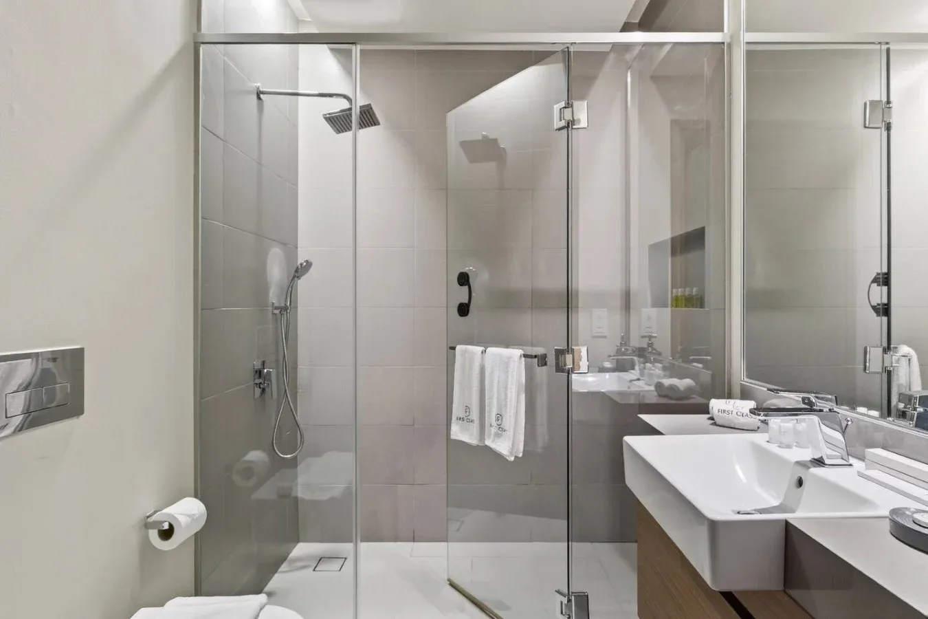 Un baño luminoso con ducha de vidrio y un lavabo amplio.