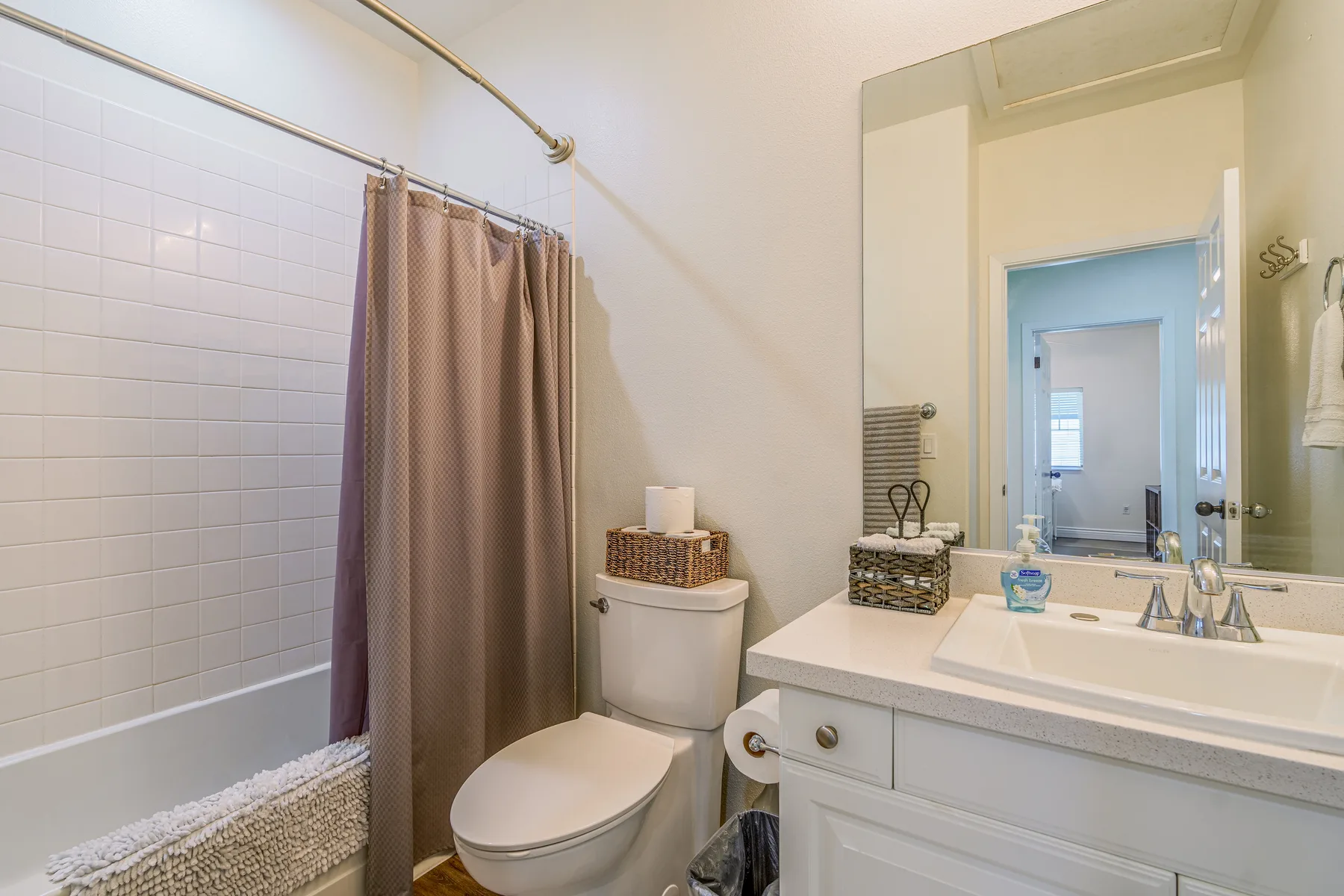 Un baño con bañera, cortina de ducha, inodoro y lavabo.