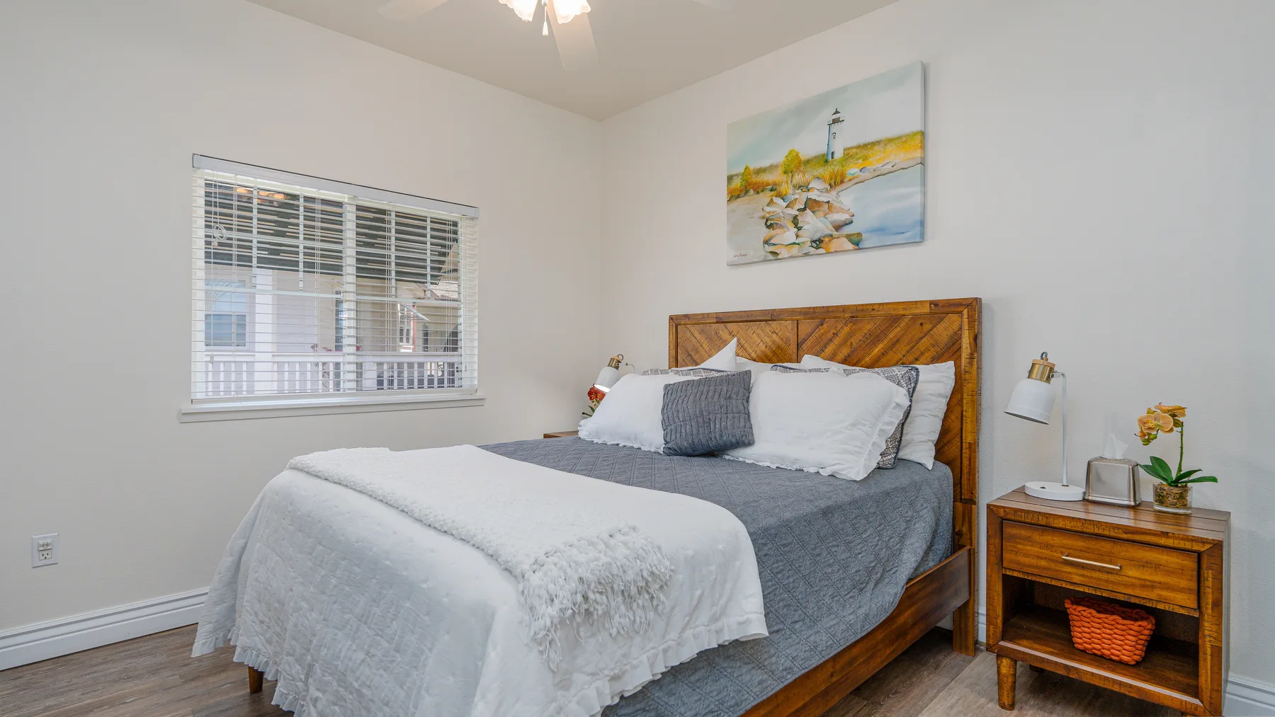 Un dormitorio con una cama, una ventana y una mesita de noche de madera.