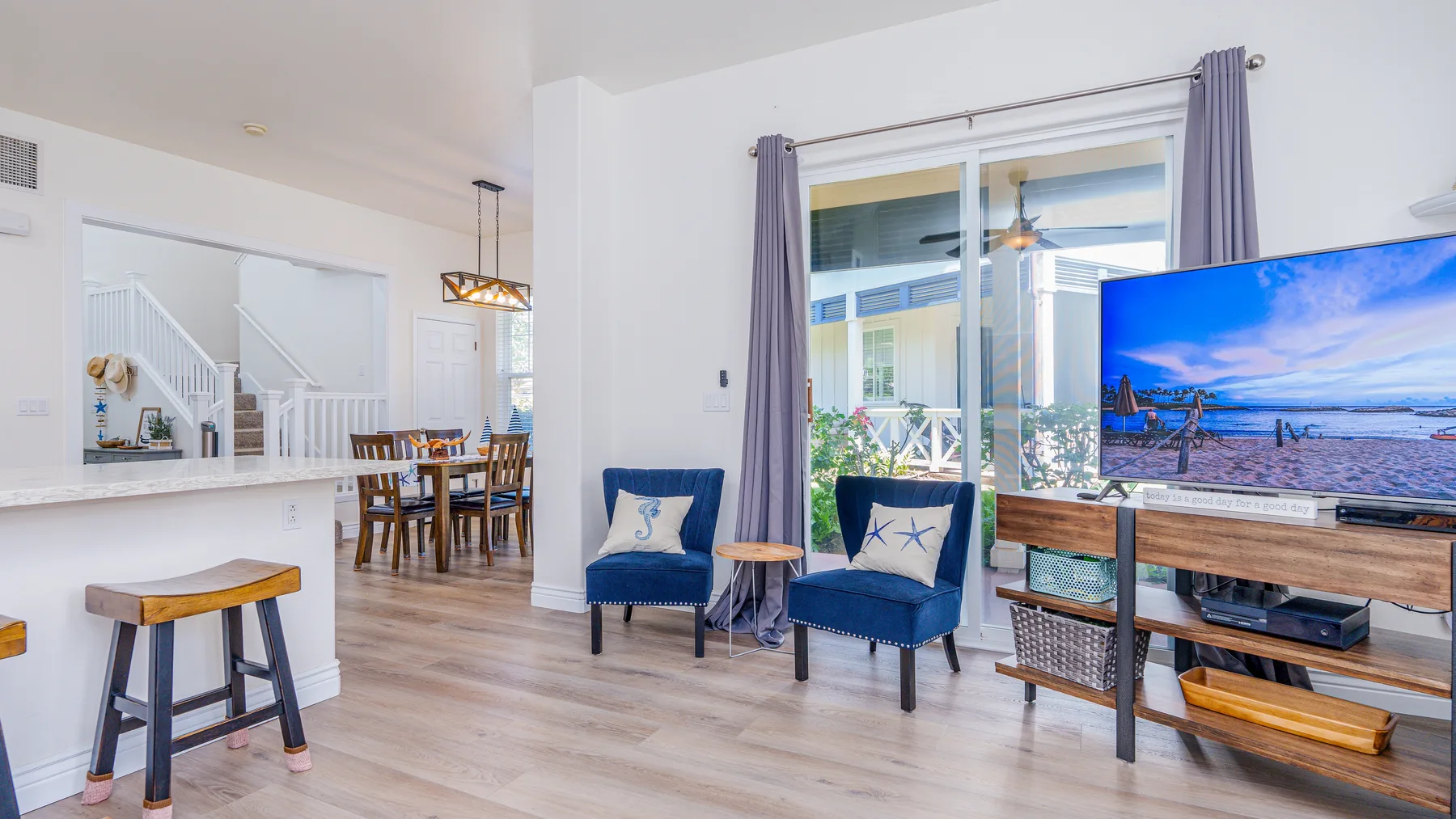 Una sala-comedor abierta tiene asientos azules y una mesa de comedor.