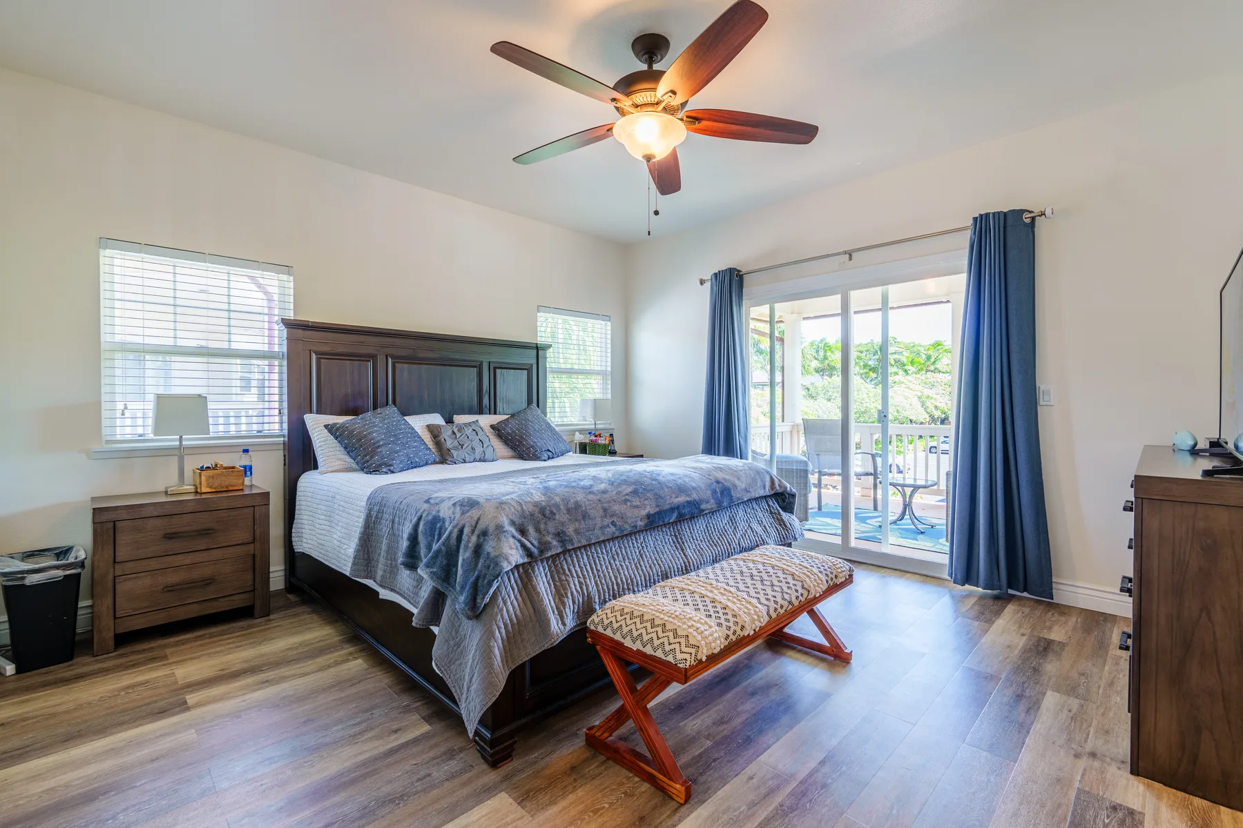 Dormitorio con una cama grande y puertas corredizas de vidrio que dan a un patio.