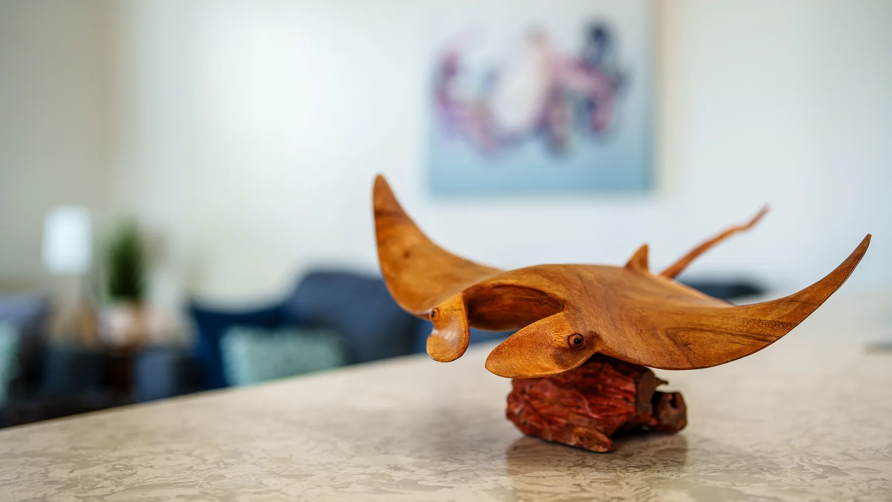 Una escultura de madera tallada reposa sobre una encimera en una sala de estar.