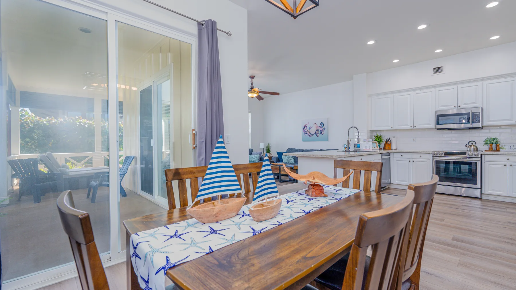Un comedor con una mesa de madera decorada con motivos náuticos azules y blancos.