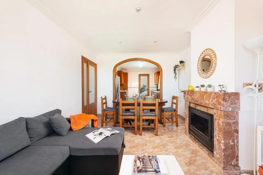 A living and dining room with seating, a wooden table, and a fireplace.