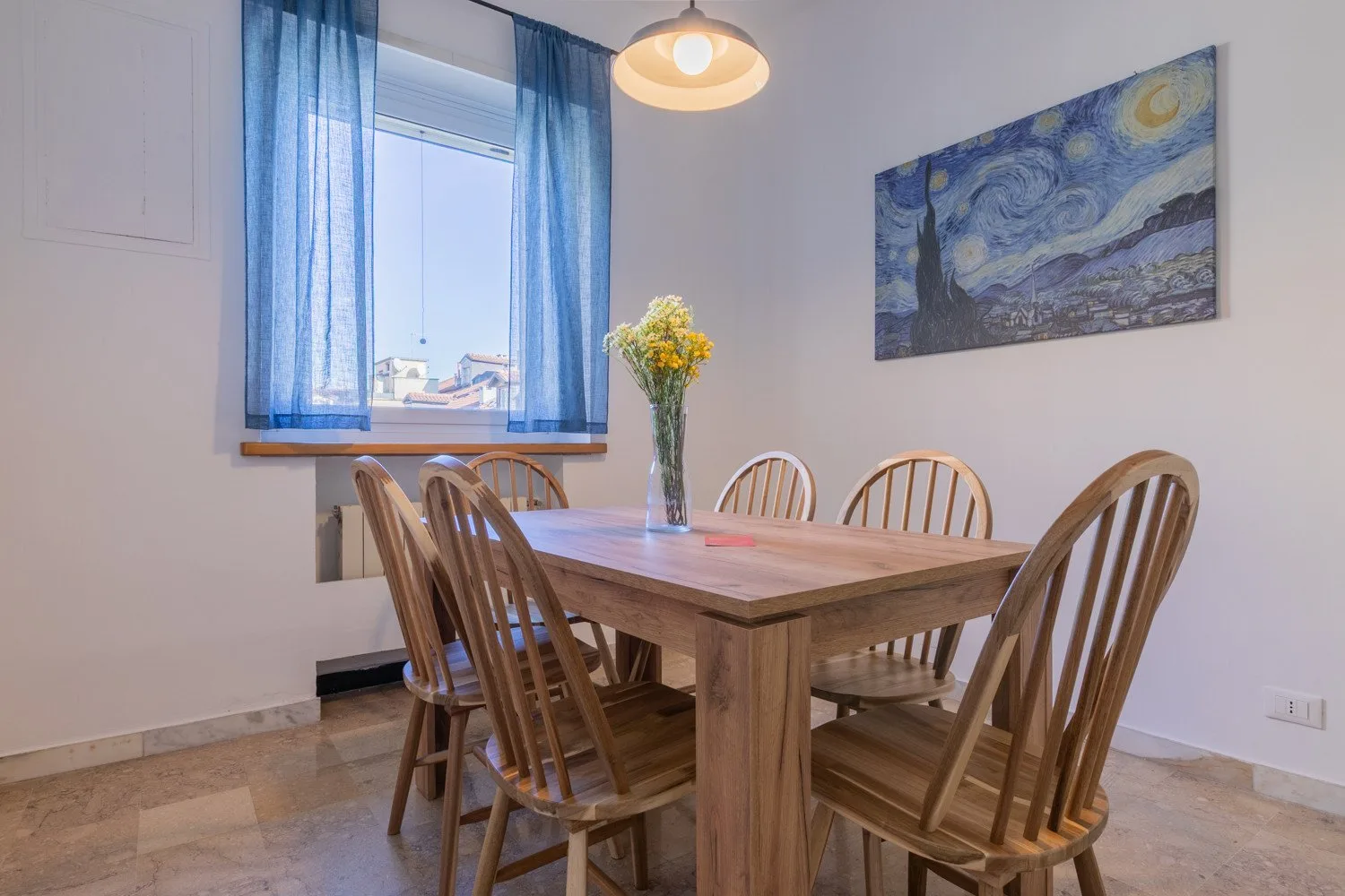 A dining area with a wooden table, seating, and blue curtains by the window.