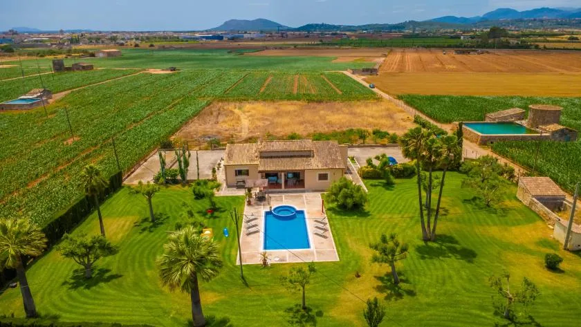 Vista aérea de una propiedad rural con piscina y campos alrededor.