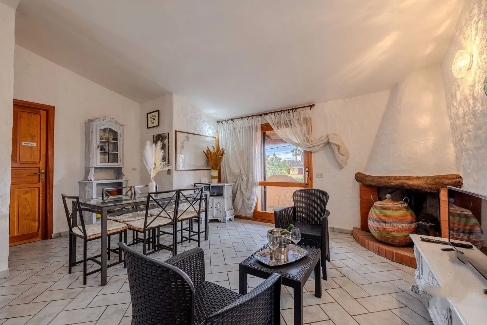 Zona de comedor y estar con mesa, sillas y chimenea.